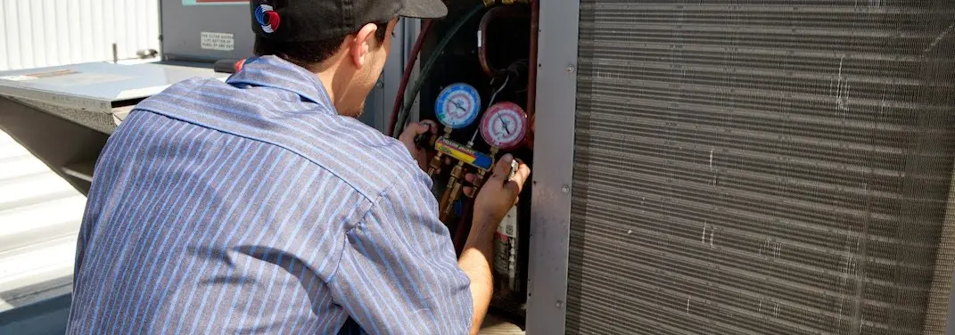 HVAC technician servicing a condenser unit in Montebello