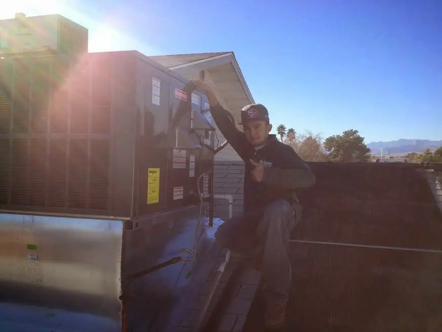 HVAC technician performing Air Duct Repair on a rooftop unit in Montebello